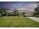 Beautiful single-story home featuring a well-manicured lawn, mature landscaping, and a two-car garage at 5465 Chestnut Ridge Rd, Dade City, FL 33523