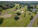 Scenic aerial view of the golf course with mature trees, sand traps, and meticulously manicured greenways at 5465 Chestnut Ridge Rd, Dade City, FL 33523