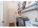 Laundry room with washer, dryer, utility sink and storage shelving on the upper wall at 5465 Chestnut Ridge Rd, Dade City, FL 33523