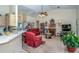 Inviting living room featuring high ceilings, plush red furniture, a cozy fireplace, and ample natural light at 5465 Chestnut Ridge Rd, Dade City, FL 33523