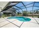 Screened-in kidney-shaped pool and patio area with an outdoor table and chairs at 5465 Chestnut Ridge Rd, Dade City, FL 33523