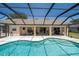 Large screened-in pool and patio area with backyard views, outdoor seating, and lounge chairs at 5465 Chestnut Ridge Rd, Dade City, FL 33523