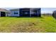 Spacious backyard featuring a covered patio, lush lawn, and black metal fence at 5920 Silver Palm Blvd, Bradenton, FL 34211