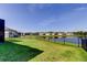 Lush backyard with a black metal fence and serene lake views, perfect for relaxation at 5920 Silver Palm Blvd, Bradenton, FL 34211