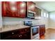 Modern kitchen features stainless steel appliances, granite countertops, and dark wood cabinets at 5920 Silver Palm Blvd, Bradenton, FL 34211