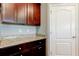 Kitchen with dark wood cabinets, granite countertops, and white door at 5920 Silver Palm Blvd, Bradenton, FL 34211