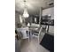 Kitchen and dining area featuring stainless appliances and a modern chandelier for ambient lighting at 611 N Bradford Ave, Tampa, FL 33609