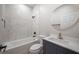 Bathroom features a shower over tub, white tile, blue vanity, and round mirror at 6215 N 44Th St, Tampa, FL 33610