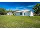 Exterior angle of the home showcasing the lush green lawn and landscaping at 6215 N 44Th St, Tampa, FL 33610