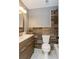 Bathroom with wood-look tiling, white toilet, wood vanity with brushed nickel hardware, and updated lighting at 6262 142Nd N Ave # 607, Clearwater, FL 33760