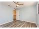Blue bedroom with wood-look flooring, ceiling fan with light, closet, and lots of natural light at 6262 142Nd N Ave # 607, Clearwater, FL 33760