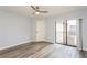A well-lit bedroom boasts wood-look floors, a fan, and access to an outdoor balcony for fresh air at 6262 142Nd N Ave # 607, Clearwater, FL 33760