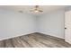 A simple bedroom is shown featuring wood-look floors, fan, and light blue paint at 6262 142Nd N Ave # 607, Clearwater, FL 33760