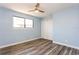 Light blue bedroom with wood-look flooring, ceiling fan with light, closet, and window at 6262 142Nd N Ave # 607, Clearwater, FL 33760