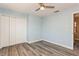 Blue bedroom with wood-look flooring, ceiling fan with light, closet, and lots of natural light at 6262 142Nd N Ave # 607, Clearwater, FL 33760