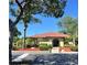 A beautifully landscaped clubhouse with a red tile roof, complemented by palm trees and lush greenery at 6262 142Nd N Ave # 607, Clearwater, FL 33760