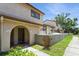Inviting townhome exterior featuring a stucco facade, arched entry, and well-maintained landscaping at 6262 142Nd N Ave # 607, Clearwater, FL 33760