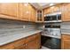 Close-up of kitchen area, featuring stainless steel stove, wooden cabinetry, and modern backsplash at 6262 142Nd N Ave # 607, Clearwater, FL 33760