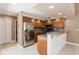 Updated kitchen features granite countertop, stainless steel refrigerator and wood cabinets at 6262 142Nd N Ave # 607, Clearwater, FL 33760
