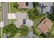 Overhead view featuring a home with solar panels and screened-in pool with well-maintained landscaping at 627 Belted Kingfisher N Dr, Palm Harbor, FL 34683