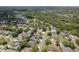 Wide aerial shot showcasing a leafy neighborhood with many residences and a serene community lake at 627 Belted Kingfisher N Dr, Palm Harbor, FL 34683