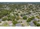Aerial view of homes nestled amongst lush trees within a neighborhood with circular streets at 627 Belted Kingfisher N Dr, Palm Harbor, FL 34683