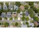 Aerial shot of a neighborhood showcasing homes with screened-in pools, solar panels, and mature trees at 627 Belted Kingfisher N Dr, Palm Harbor, FL 34683