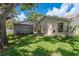 Spacious backyard with mature trees, lush grass, and a screened-in pool area, perfect for entertaining at 627 Belted Kingfisher N Dr, Palm Harbor, FL 34683