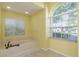 Bright bathroom featuring tile floors, large soaking tub, and a large arched window with natural light at 627 Belted Kingfisher N Dr, Palm Harbor, FL 34683