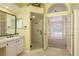 Bathroom featuring walk-in shower, vanity, and view of the outdoor pool through glass doors at 627 Belted Kingfisher N Dr, Palm Harbor, FL 34683