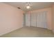 Bedroom features a ceiling fan, carpeted floor, closet, and access to the attached bathroom at 627 Belted Kingfisher N Dr, Palm Harbor, FL 34683