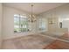 Bright dining room with large windows, a decorative chandelier, and mirrored wall at 627 Belted Kingfisher N Dr, Palm Harbor, FL 34683