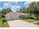 Charming single-story home with a three-car garage, well-manicured lawn, and attractive landscaping at 627 Belted Kingfisher N Dr, Palm Harbor, FL 34683