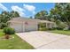 Inviting single-story home with a three-car garage, spacious driveway, and well-kept landscaping at 627 Belted Kingfisher N Dr, Palm Harbor, FL 34683