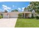 Charming single-story home with an attached three-car garage and well-manicured lawn at 627 Belted Kingfisher N Dr, Palm Harbor, FL 34683