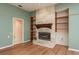 Charming living room featuring a stone fireplace, built-in shelves, and hardwood flooring at 627 Belted Kingfisher N Dr, Palm Harbor, FL 34683