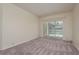 Light-filled living room with neutral carpet and sliding doors overlooking the pool area at 627 Belted Kingfisher N Dr, Palm Harbor, FL 34683