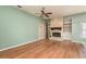 Cozy living room with a stone fireplace, built-in shelves, and hardwood floors at 627 Belted Kingfisher N Dr, Palm Harbor, FL 34683
