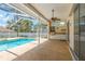 Outdoor patio with built-in kitchen and barbecue area, ceiling fan, and access to pool and spa at 627 Belted Kingfisher N Dr, Palm Harbor, FL 34683