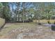 A spacious backyard features a patio area and is surrounded by a wooden fence and mature trees at 6347 S Lansdale Cir, Tampa, FL 33616