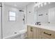 Bathroom featuring a marble-look tile shower and wood vanity with a marble countertop at 6347 S Lansdale Cir, Tampa, FL 33616