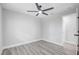 A bright bedroom featuring sleek wood-look floors, a modern ceiling fan, and neutral paint at 6347 S Lansdale Cir, Tampa, FL 33616