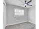 This bedroom boasts wood-look flooring, ceiling fan, and a large window for natural light at 6347 S Lansdale Cir, Tampa, FL 33616