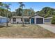 Single-story home featuring a one-car garage, xeriscaping, and a pop of color with its blue door at 6347 S Lansdale Cir, Tampa, FL 33616
