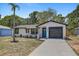 Attractive single-story home with a tidy lawn, black trim, and a blue front door at 6347 S Lansdale Cir, Tampa, FL 33616