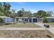 Inviting single-story home with a blue front door and palm trees in the front yard at 6347 S Lansdale Cir, Tampa, FL 33616
