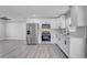 Modern kitchen featuring stainless steel appliances, white cabinets, and wood-look flooring at 6347 S Lansdale Cir, Tampa, FL 33616