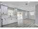Open kitchen and dining area with modern white cabinets, stainless appliances, and wood-look flooring at 6347 S Lansdale Cir, Tampa, FL 33616