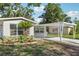 Close-up of a single-story house with fresh landscaping and a covered carport at 7110 Bonito St, Tampa, FL 33617