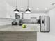 Open kitchen view with island, stainless appliances, and marble floor at 7110 Bonito St, Tampa, FL 33617